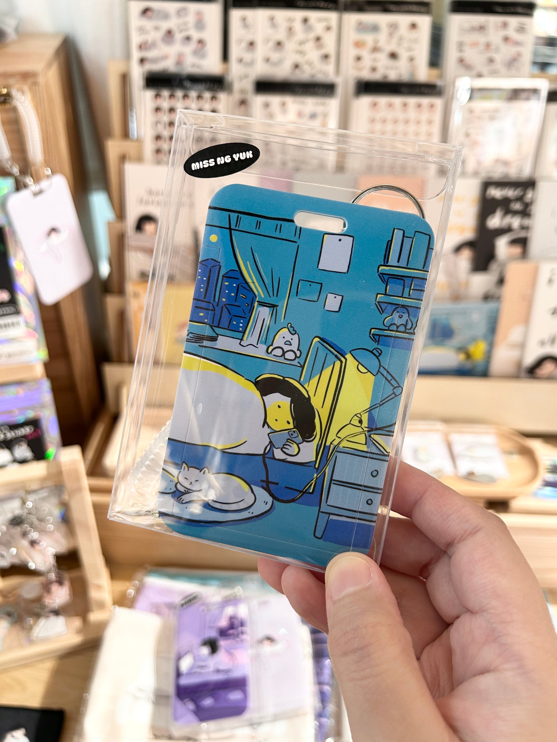 Miss Ng Yuk Rot in Peace with my Phone sliding badge holder featuring a colorful, humorous design on a clear background.