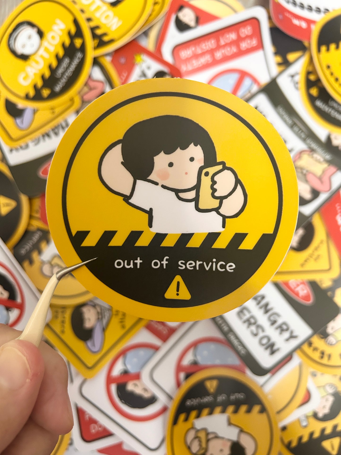 Vinyl sticker with humorous text "Out of Service" surrounded by other stickers.