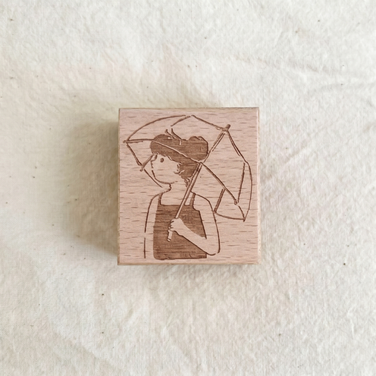 Cute girl with umbrella stamp from PAPER GOODS BY DORIE featuring a rainy day scene, perfect for crafting projects.